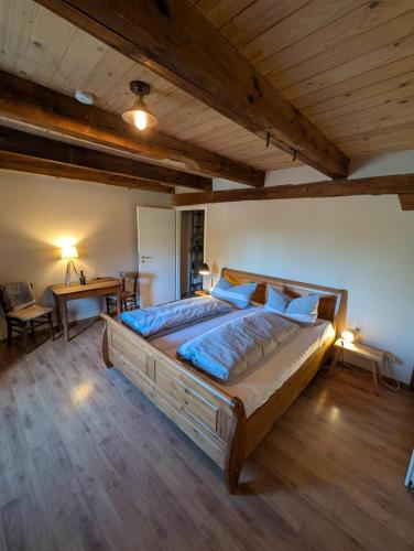 a bedroom with a large bed and a desk at Pension Müllers Mühle in Großenhain
