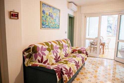 a living room with a couch and a painting on the wall at Appartamento l'Isola D'Oro in Grado