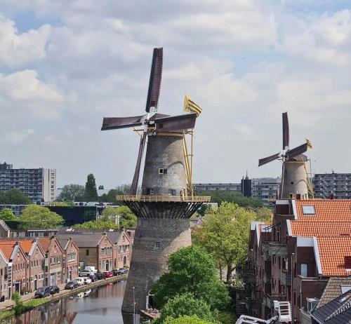two windmills on a river in a city at Windmill view Apartment in Schiedam