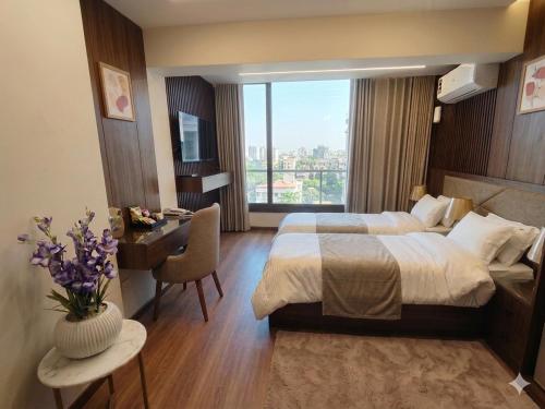 a hotel room with a bed and a desk and a window at Azurea Suites in Alexandria