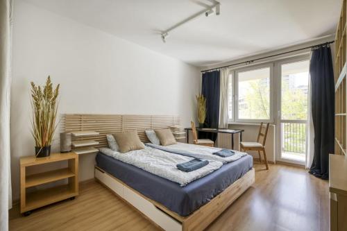 a bedroom with a large bed and a desk at Śliska Residence in Warsaw