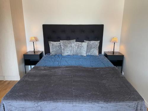 a bedroom with a blue bed with two night stands at Fully equipped guest apartment with parking in Upplands-Väsby