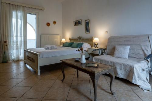 a bedroom with two beds and a couch and a table at Kythaeri Studios in Frátsia