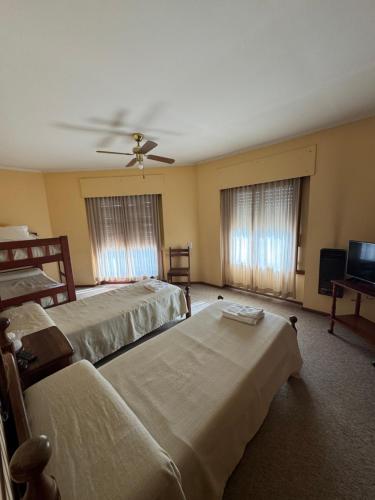 a bedroom with two beds and a ceiling fan at Hotel Guamini in Guaminí