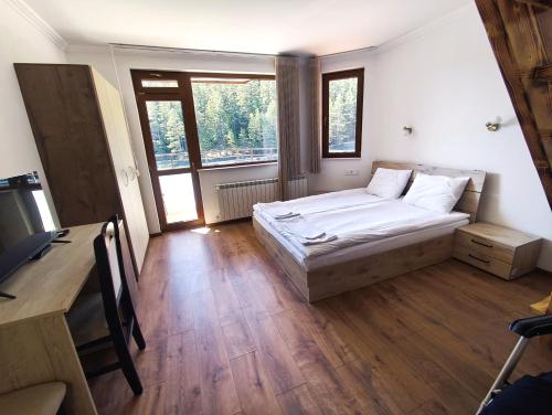 a bedroom with a bed and a desk and window at Daisy Forest in Borino