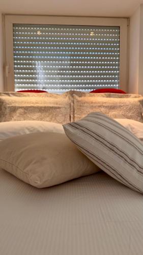 a bed with two pillows on it with a window at Messapia Homes in Mesagne