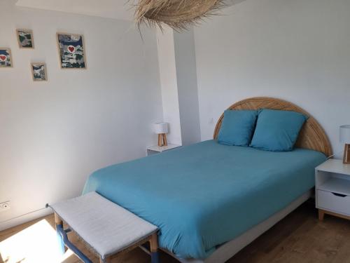 a bedroom with a blue bed and a chair at Villa avec jardin,proche port du Crouesty 500 m et des plages 2km in Arzon
