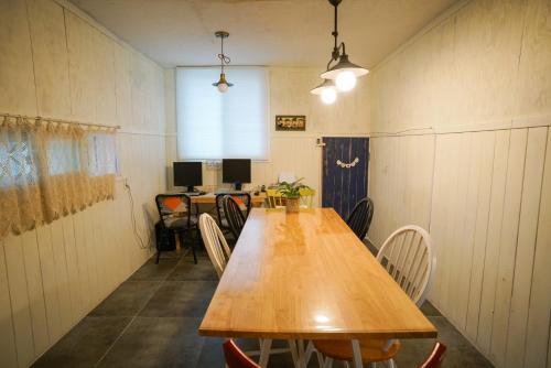 a long wooden table in a room with chairs at Suncheon Namu Guesthouse in Suncheon