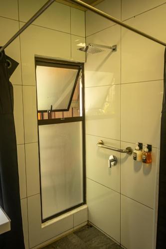 a shower with a glass door with a mirror at Riverside Villas in Manuel Antonio