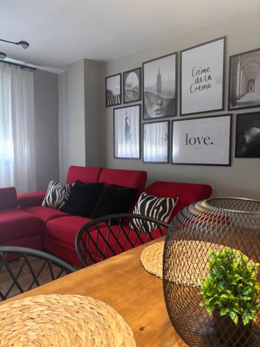 a living room with a red couch and a table at Las Casas de Lola in Candeleda
