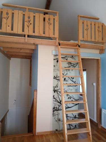 a loft bed with wine racks in a room at Les Petites Maïs in Nantes-en-Rattier