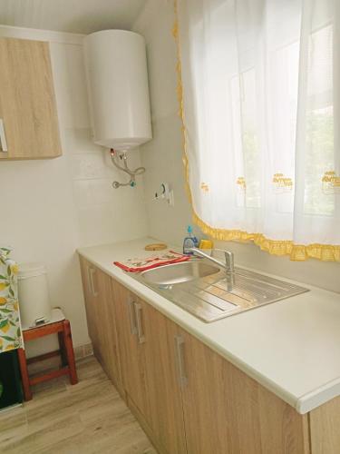 a kitchen counter with a sink and a window at Estúdio ensolarado in Fernao Ferro