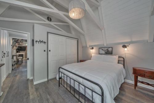 a bedroom with a large white bed and a table at Secluded River Cabin Near Sly Park & Apple Hill in Placerville