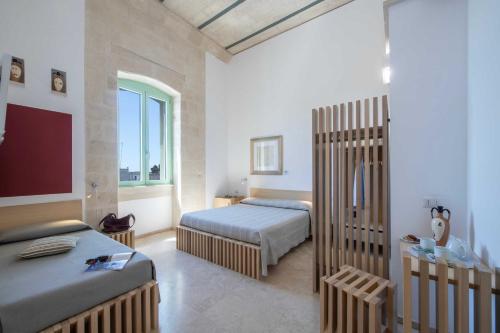 a bedroom with two beds and a large window at La Filanda Salento in Casamassella