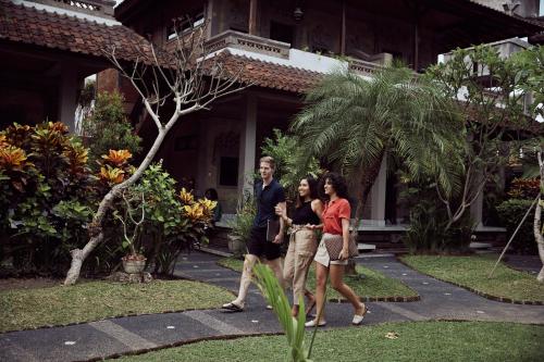 a group of three people walking in front of a building at Outpost Ubud Nyuh Kuning in Ubud
