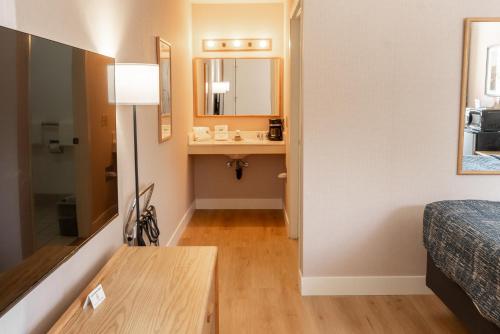 a room with a bed and a table and a mirror at Prospector Inn in Escalante