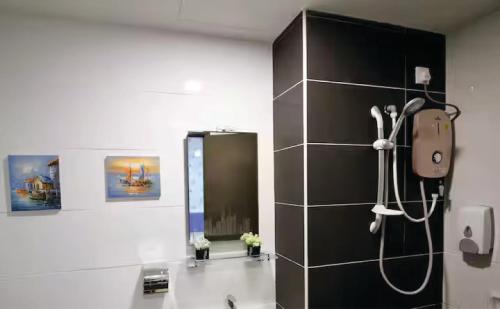 a bathroom with a shower with a black wall at Majestic Cottage in Ipoh