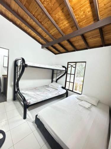 a bedroom with two bunk beds and a wooden ceiling at Casa con PISCINA PRIVADA Cielito in Flandes
