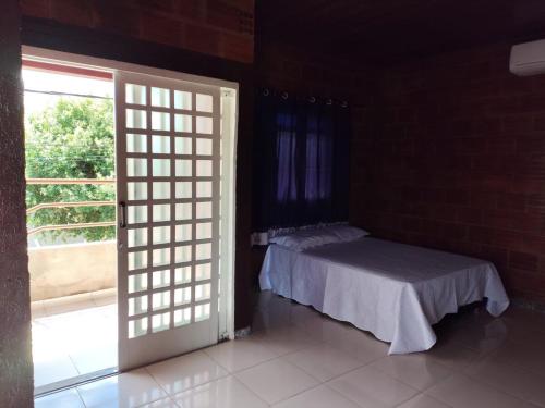 a bedroom with a bed in a room with a window at Kitnet Rústica! in Januária