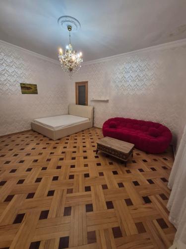 a living room with a red couch and a bed at Milo Comfort 2 in Rustavi