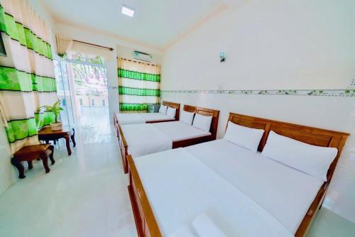 two beds in a room with green and white walls at Motel Tiến Phúc in Long Hai