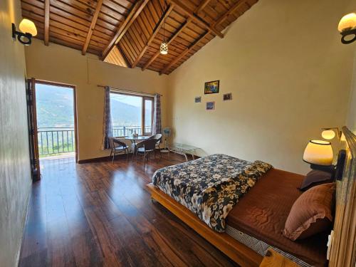 a bedroom with a bed and a table with chairs at Saanidhya Homestay in Mukteshwar