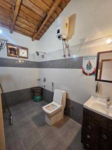 a bathroom with a toilet and a sink at Saanidhya Homestay in Mukteshwar