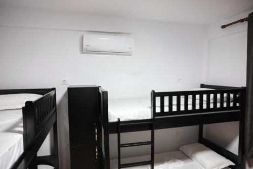 two bunk beds in a room with a white wall at Berat Hill Hostel in Berat