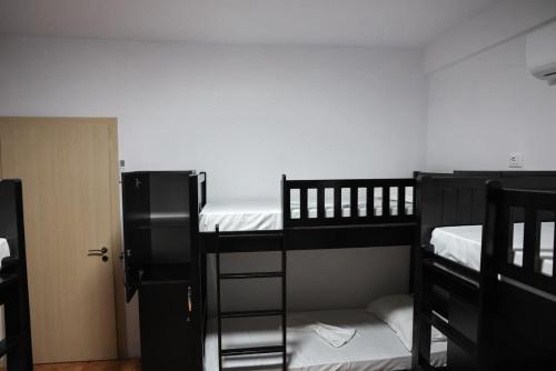 two black bunk beds in a room with a door at Berat Hill Hostel in Berat