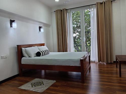 a bedroom with a bed and a large window at Misty Edge Hanthana in Kandy