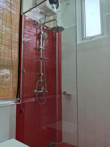 a shower in a bathroom with a red wall at Misty Edge Hanthana in Kandy