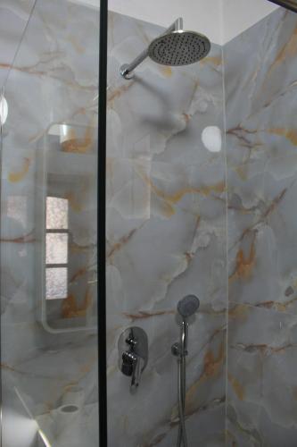 a bathroom with a shower with a glass door at Casa Elefteria & Viron in Himare