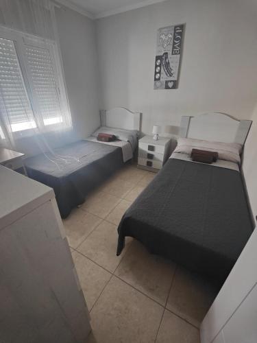 a bedroom with two beds and a window at Vinaros Modern Apartment in Vinarós