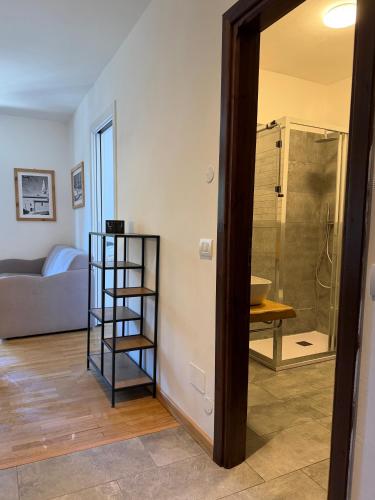 a bathroom with a shower and a shelf in a room at Le Grange Apartments - Direct Ski Access in Sauze dʼOulx