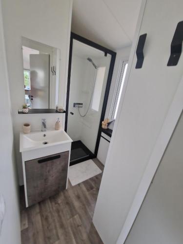 a bathroom with a sink and a mirror at Camping Oléron Cap Soleil MH Climatisé in Saint-Denis-dʼOléron