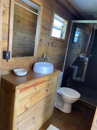a bathroom with a sink and a toilet at Suítes Âncora Praia do Rosa in Imbituba