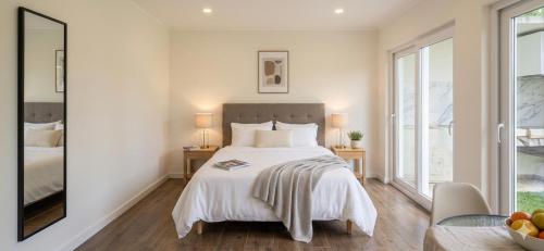 a bedroom with a bed and two tables with lamps at Green cabin in our small garden in Arruda dos Vinhos