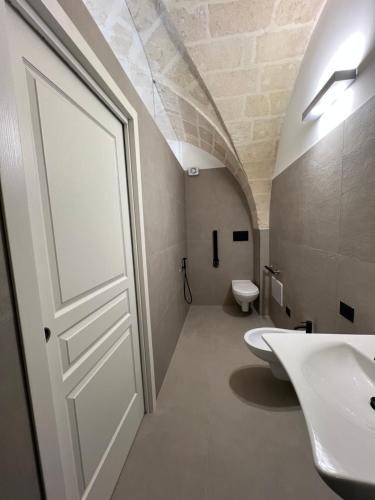 a bathroom with a white door and a sink at Giù al Vigneto in Leporano