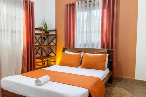 a bedroom with a bed with orange and white pillows at confortable calme , wifi gratuit in Antananarivo