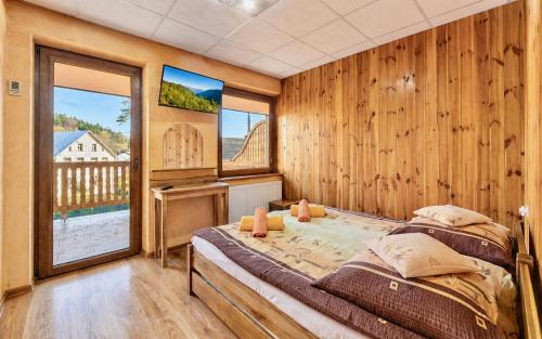 a bedroom with two beds in a room with wooden walls at Pod Smerkami in Szklarska Poręba