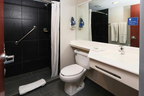 a bathroom with a toilet and a sink and a shower at City Express by Marriott Tampico in Tampico