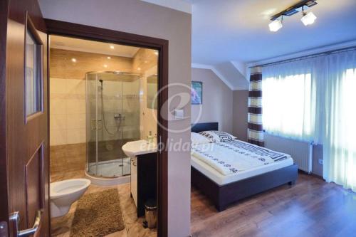 a bathroom with a bed and a shower and a sink at Na Jurze in Mirów