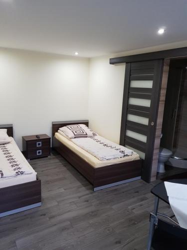 two beds in a room with wooden floors at Na Jurze in Mirów