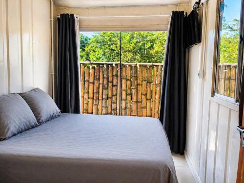 a bedroom with a bed in front of a window at Condominio Vila Contanainer in Morretes