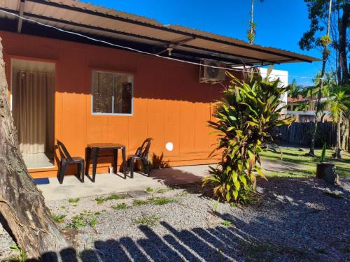 a house with a table and chairs in front of it at Condominio Vila Contanainer in Morretes