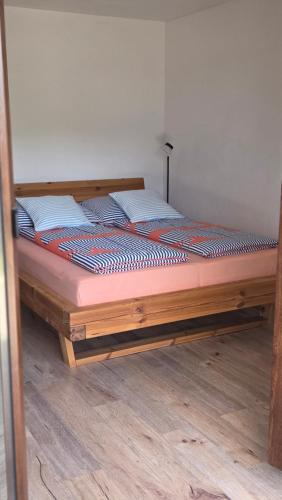 a bed with a wooden frame in a room at Appartement Demelfischer am See in Altmünster