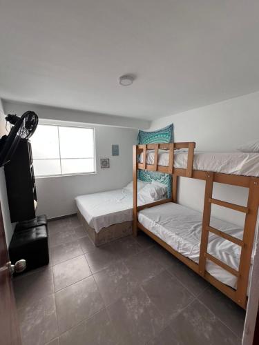 a room with two bunk beds and a window at Los Pulpos Beach House in Bombiso