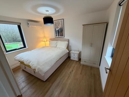 a small bedroom with a bed and a window at The Bat Barn in Corsley