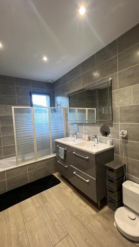 a bathroom with a sink and a tub and a toilet at Chez TIKA in Saint-Lager