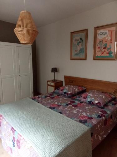 a bedroom with a bed with a quilt on it at Gite du Vidame in Montsoreau